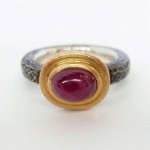 Ruby cabochon set in 18 kt. gold and sterling silver