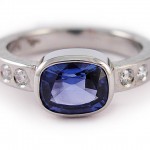 Cushion cut blue sapphire and brilliant cut diamonds set in 19 kt. white gold