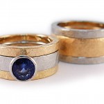 Sets of stacking rings in 19 kt. white gold and 18 kt. yellow gold, one ring set with blue sapphire