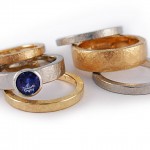 Sets of stacking rings in 19 kt. white gold and 18 kt. yellow gold, one ring set with blue sapphire